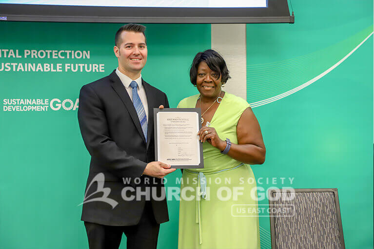 NYS Assemblywoman Crystal Peoples-Stokes holding up a signed MOU to support ASEZ WAO