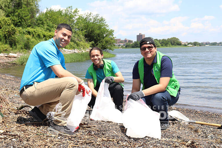 ASEZ student volunteers happily making Clason Point Park clean and safe.