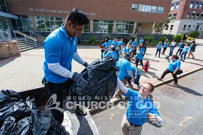 Volunteers from ASEZ moving trash bags off the street into a truck in Albany.