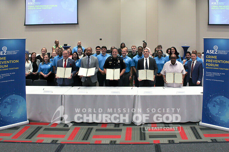 Speakers holding up signed MOUs during ASEZ's Crime Prevention Forum in Louisville, KY