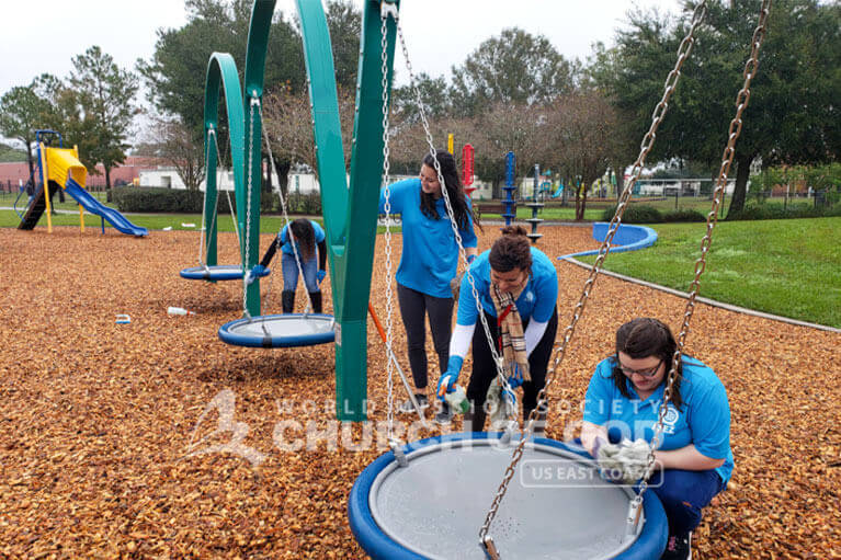 ASEZ student volunteers cleaning the playground at Leroy Hoequist Park.