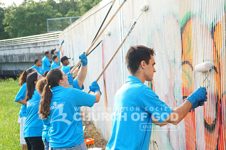 ASEZ volunteers removing graffiti from wall in Orlando.