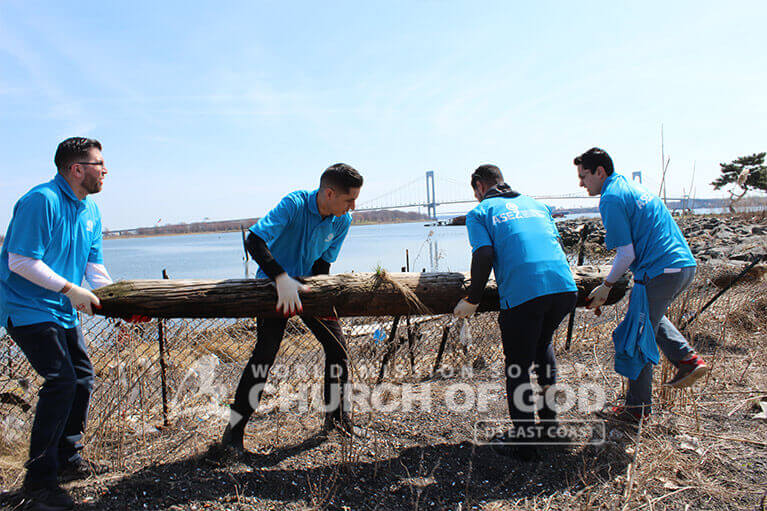 ASEZ volunteers carrying off a decaying log at Clason Point Park.